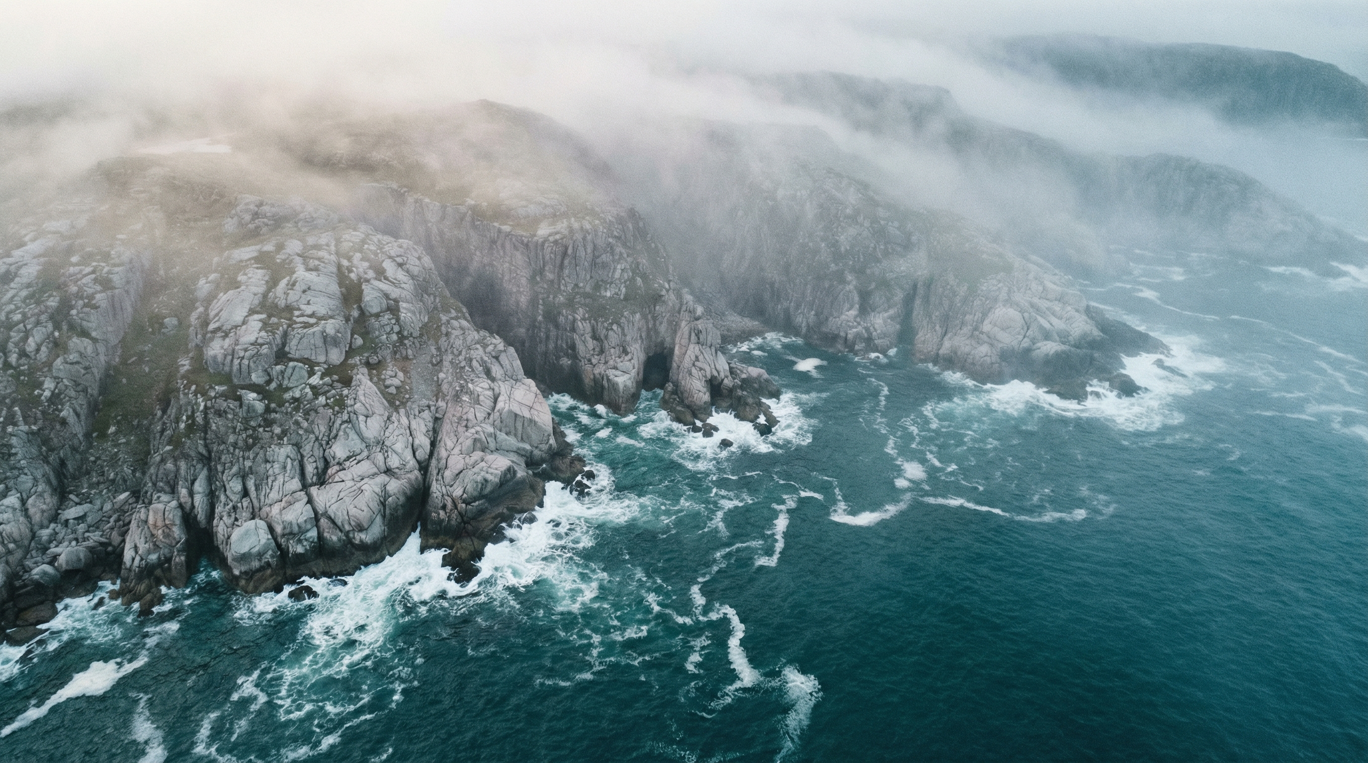 Rugged, misty Scandinavian coastline with cold surf